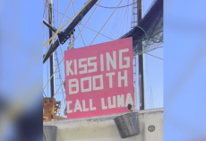Tourists Spot ‘Kissing Booth’ Sign On Docked Boat — Then A Sweet Dog Pops Into View